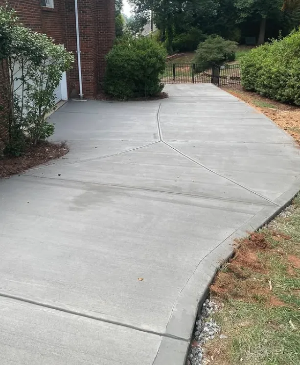 Curved concrete driveway beside a brick home