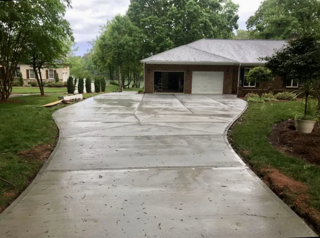 Wide concrete driveway in front of a brick home