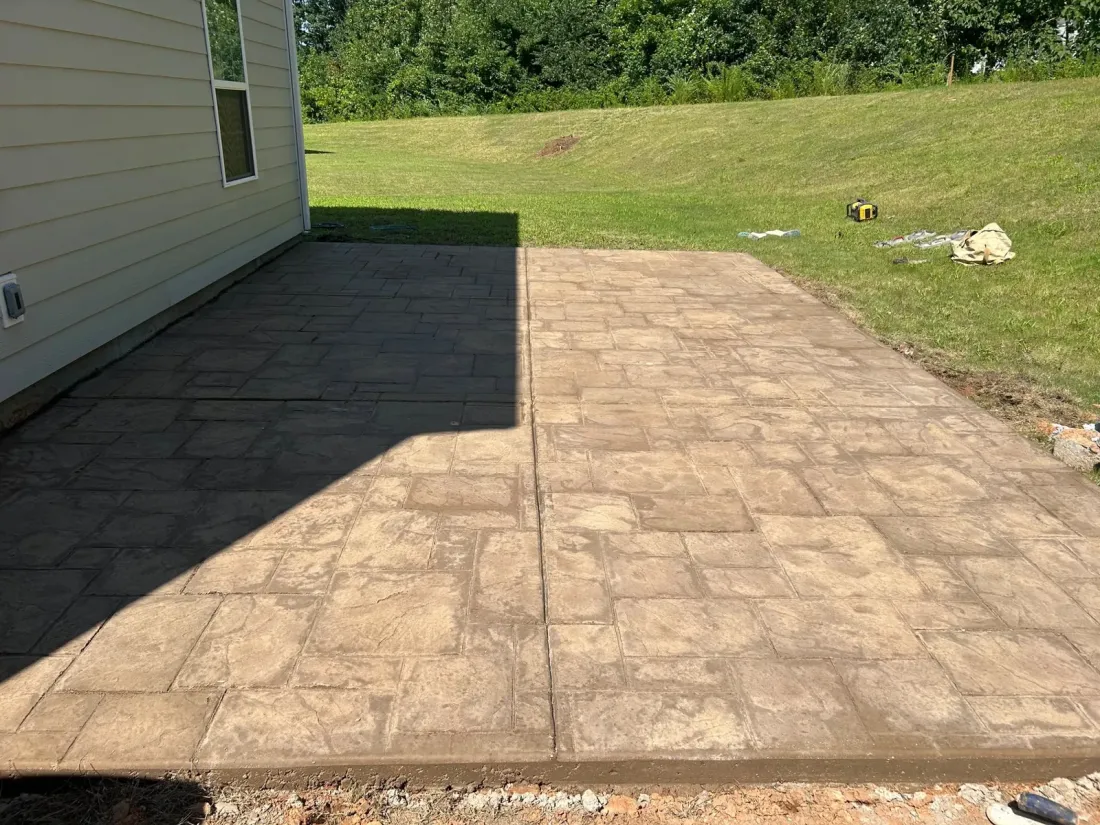 Tan stamped concrete patio beside a home